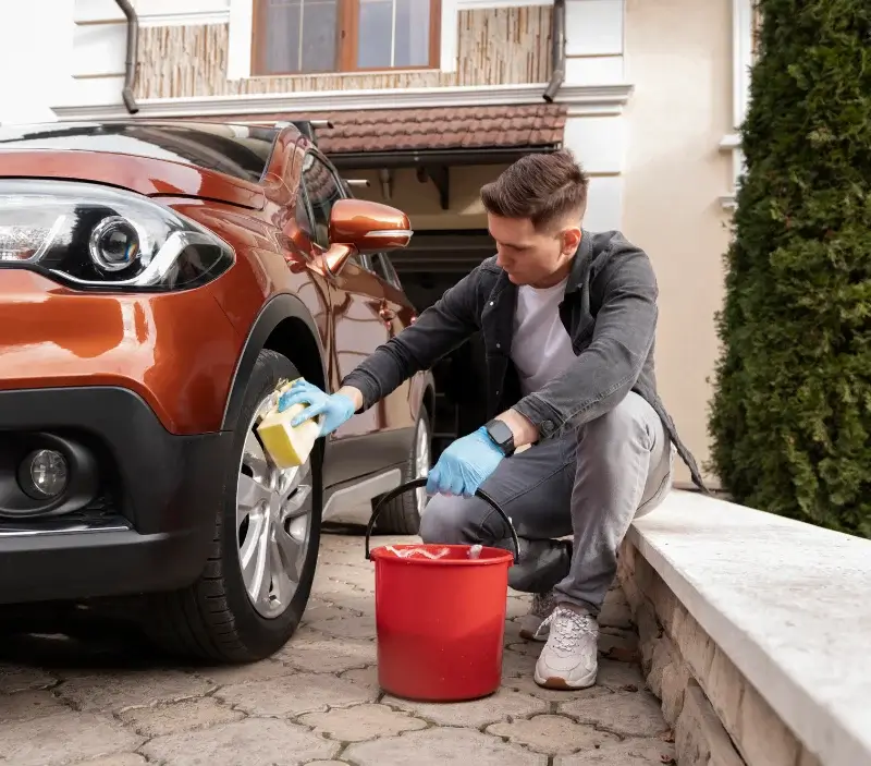 Lavage auto à domicile Voisins-le-Bretonneux : professionnel intervenant sur un véhicule